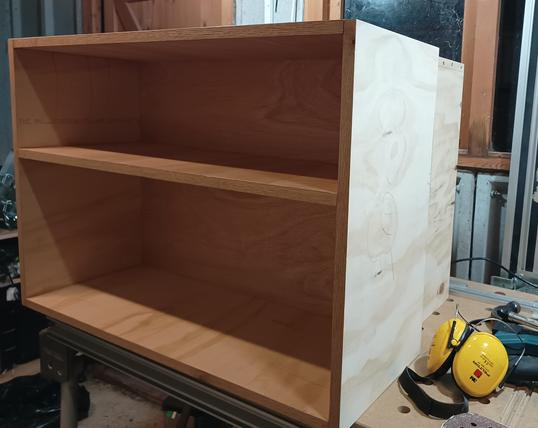 A photo of two small bookshelves on top of a workbench