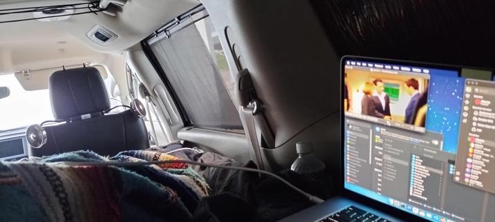 Inside of my van, showing some blankets and laptop