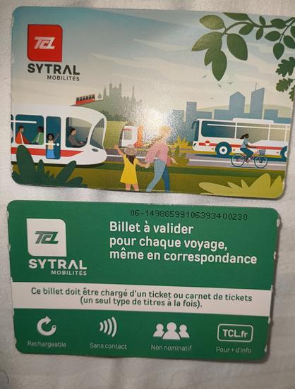 Face and reverse of a ticket. Credit card sized.
One side has graphics of a tram, bus, metro, bicycle and the funiculaire.
A child on foot is waving to another on a tram.
A tree is visible.
The reverse has instructions for use in French. The card is contact less.