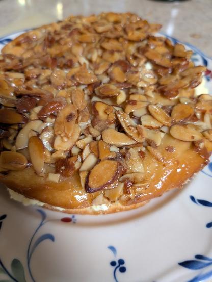 A picture of a cake with the top crusted with almonds and honey
