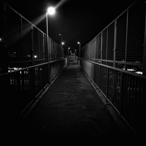 a bridge over a train track, a lamp post, very symetrical