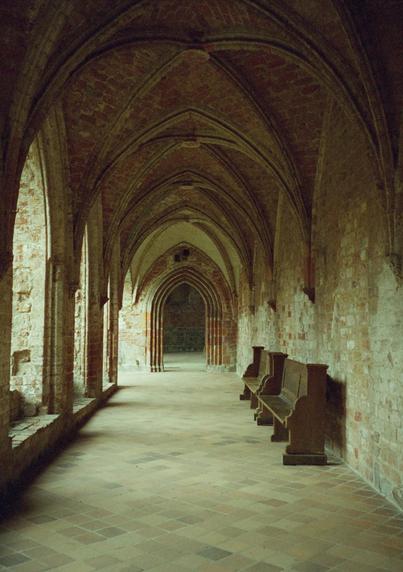 Cloister featuring archway and two wooden banks