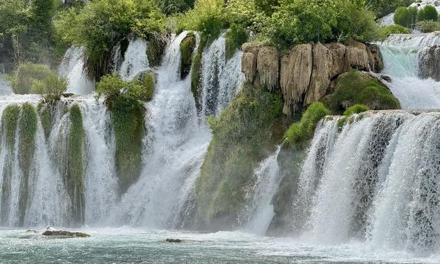 Tufa barrier forming waterfall in karst landscape