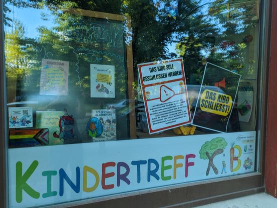 Das komplette Schaufenster des KiBo. Unten ein Streifen aus farbigen Buchstaben: "Kindertreff Kibo".