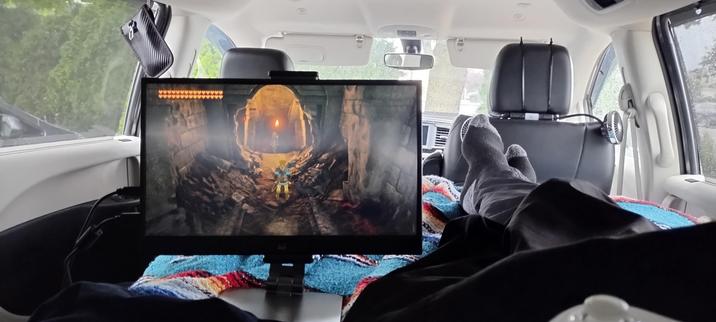 Photo of inside my van showing my feet resting next to a portable monitor for Nintendo Switch, with Zelda Tears of the Kingdom showing on screen