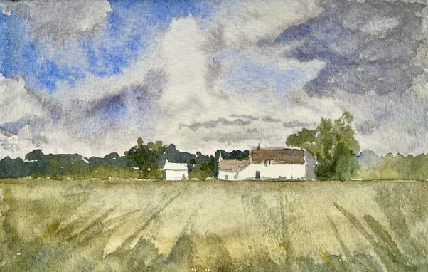 A cluster of small, white buildings with sloped roofs sits quietly at the edge of an open field, beneath a vast sky where broad, sweeping clouds drift above a distant tree line.