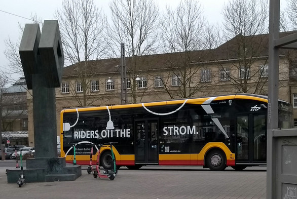 E-Bus der KVV mit Slogan "RIDERS ON THE STROM". Das N von "ON" wird gebildet von den Pins eines von oben kommenden stilisierten Netzsteckers.