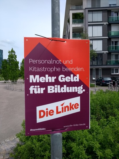 Wahlplakat der Linken beim Citypark Karlsruhe:
"Personalnot und Kitastrophe beenden
(Groß und fett) Mehr Geld für Bildung"