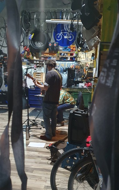 Sänger mit Gitarre mitten im Radladen