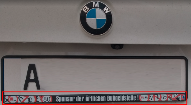 Nummernschild eines BMW- SUV.
Auf dem Nummernschildträger Bilder von Verbots- und Tempolimitschildern mit Slogan "Sponsor der örtlichen Bußgeldstelle!"