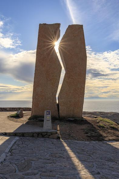 Denkmal an der Costa da Morte als Erinnerung an das Tankerunglück des Öltankers Prestige. 2 Steinsäulen durch den Spalt scheint die Sonne