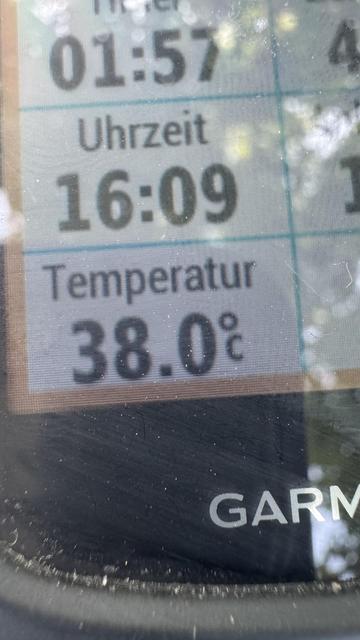 Ein elektronisches Display zeigt die Uhrzeit als 16:09 und die Temperatur als 38,0°C an. Das Gerät scheint ein Garmin-Modell zu sein.