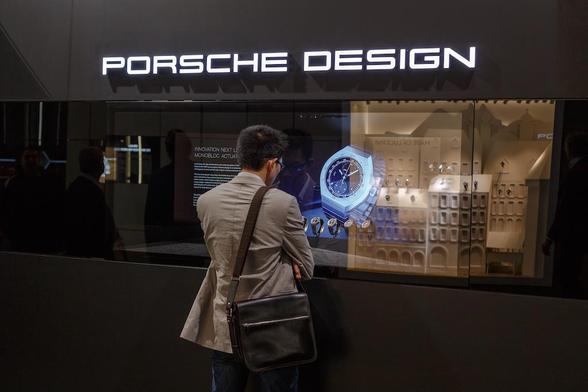 Ein Mann steht vor einem Schaufenster und betrachtet die Uhren in der Auslage, darüber steht Porsche Design